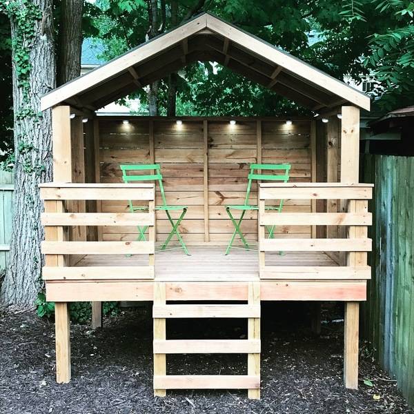 kids raised wood playhouse with ladder and two chairs